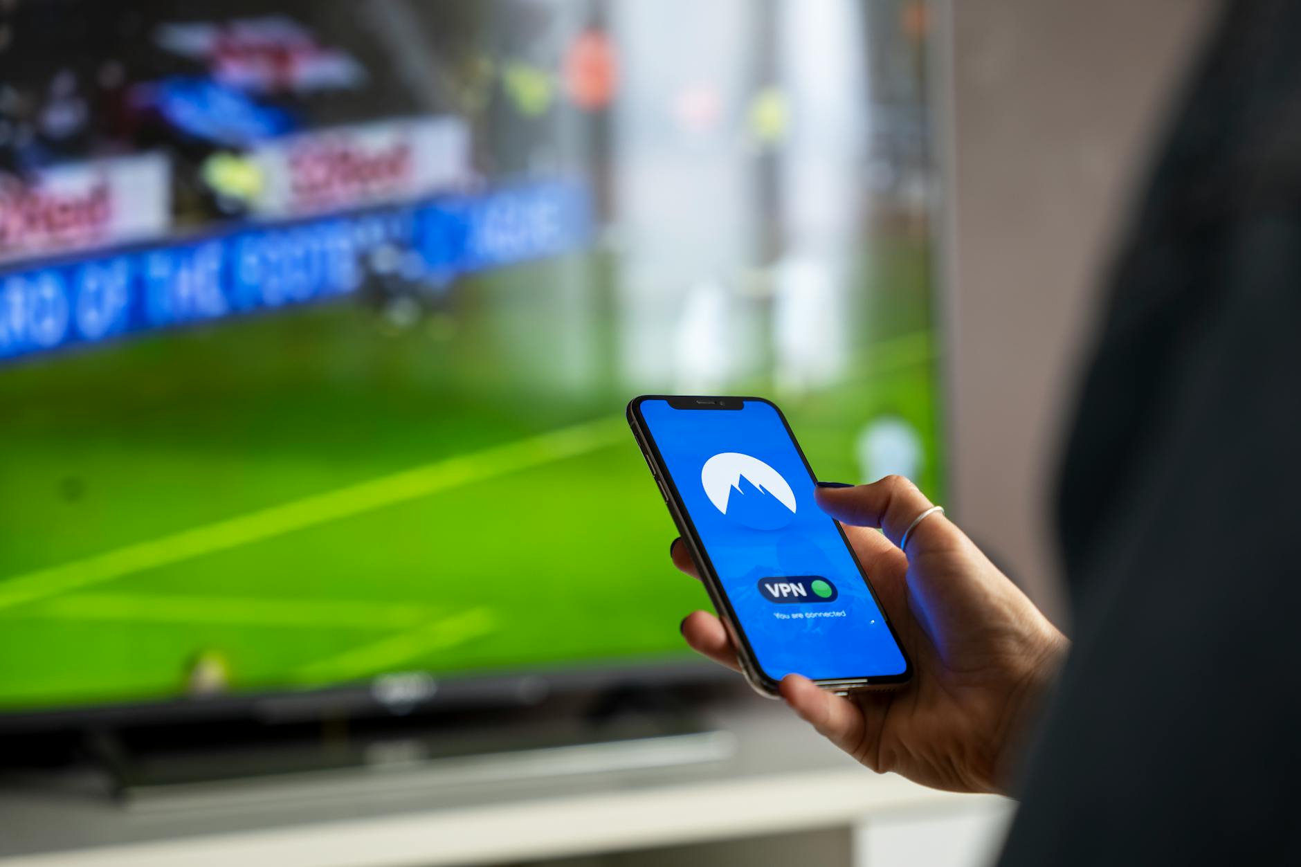 Person using remote control to navigate streaming content on large screen television