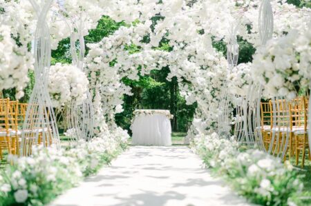 Wedding planner meeting with couple at table with planning materials and notebooks