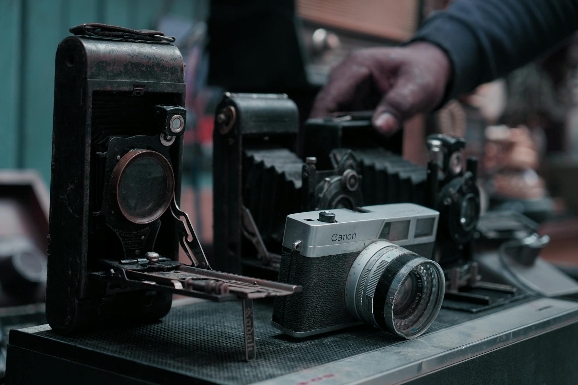 Collection of vintage film cameras displayed on wooden surface showing various classic models
