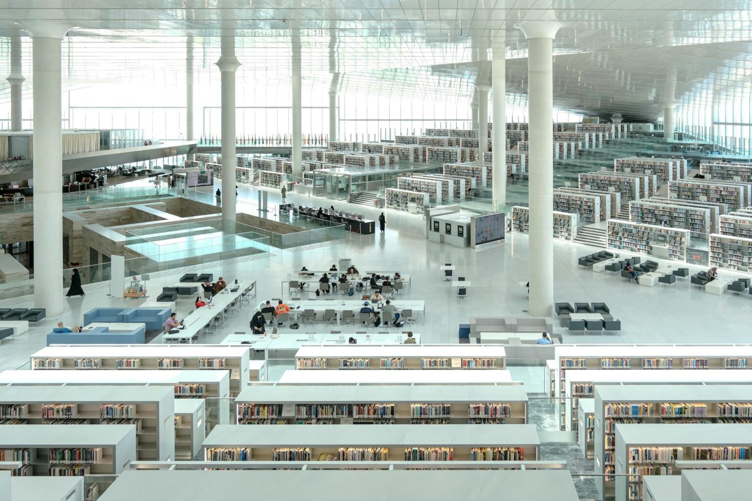 Interior view of public library with reading tables and bookshelves