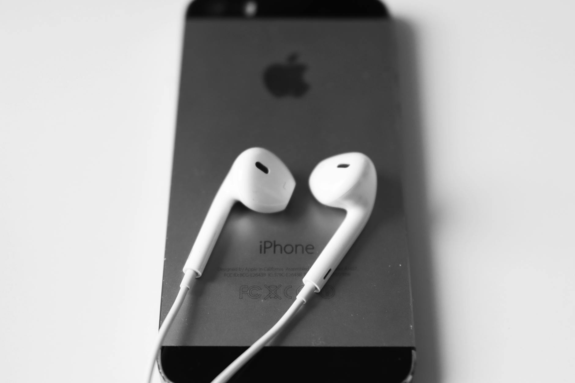 Person holding smartphone with headphones, representing digital music consumption and streaming habits