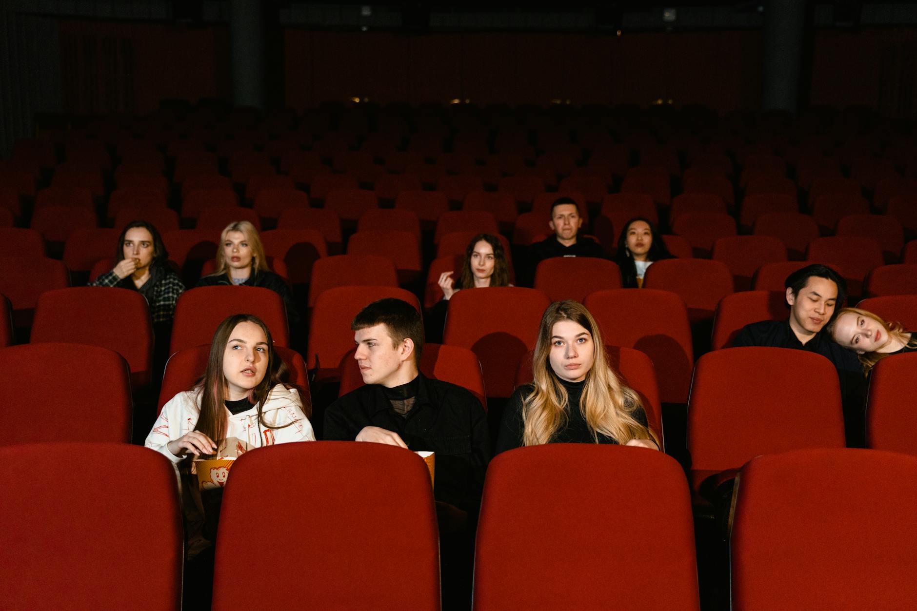 Theater audience watching a Broadway performance in darkened auditorium with stage lights