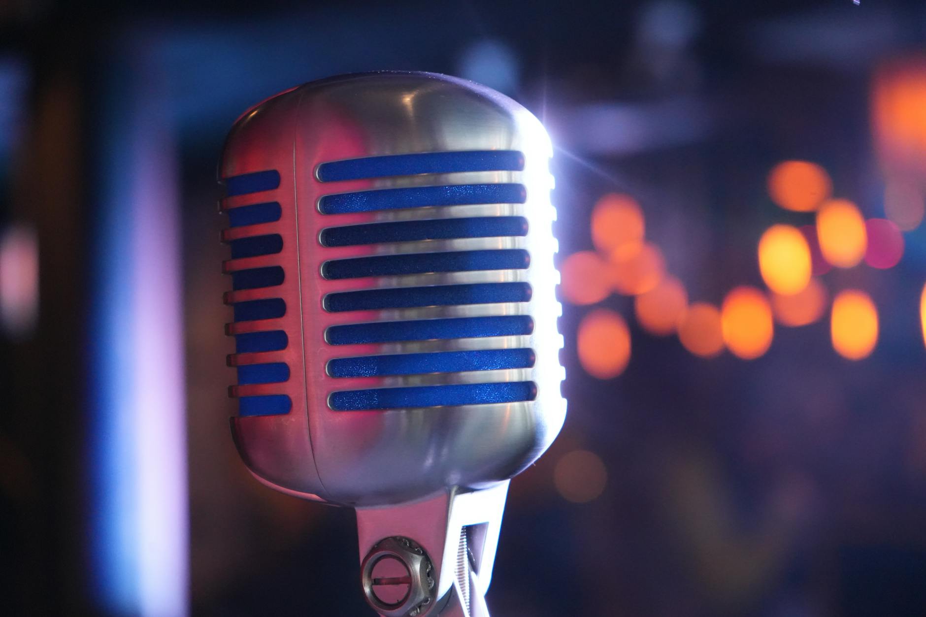 Close-up of microphone on comedy club stage with dim lighting
