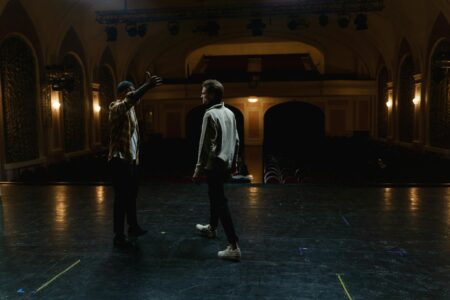 Empty theater stage with dramatic lighting and red curtains