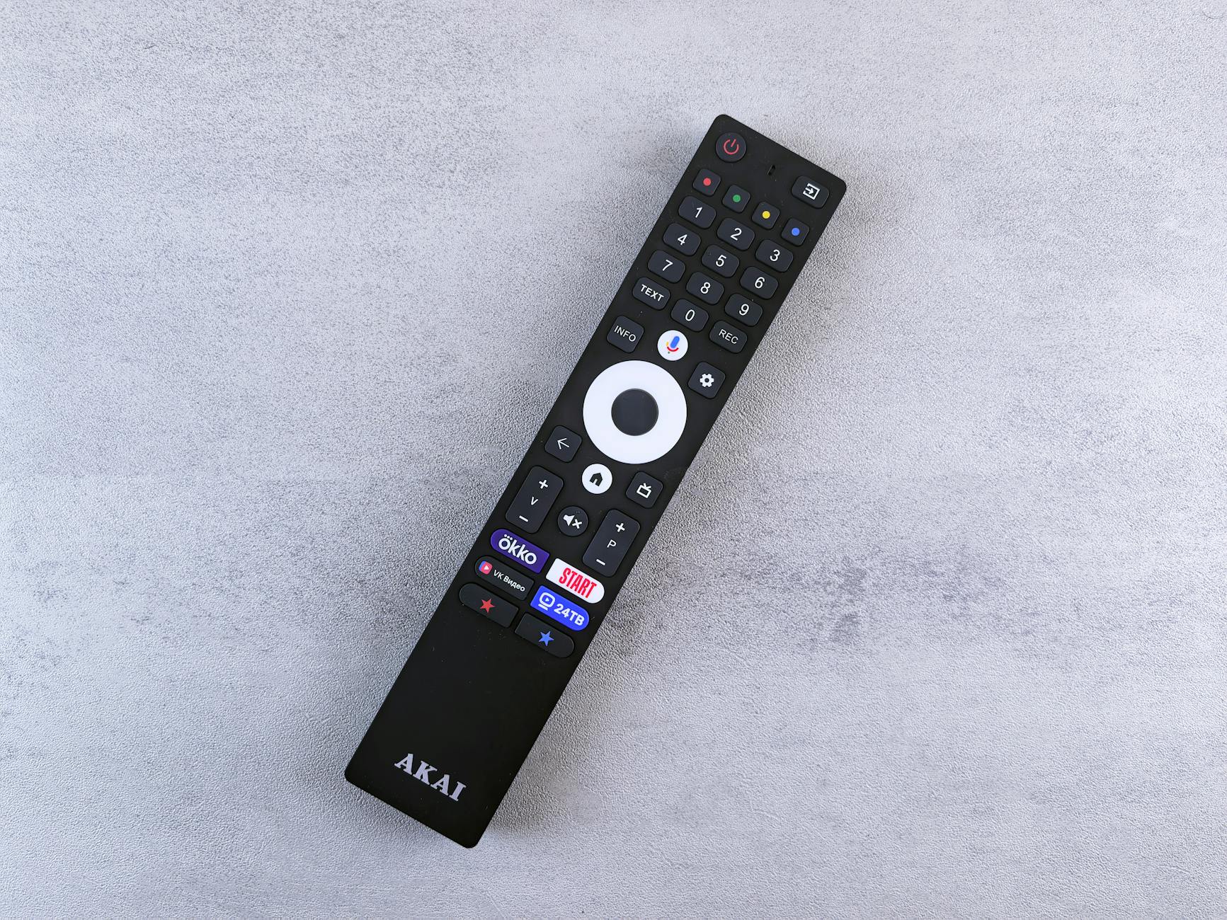 Hand holding TV remote control pointing at screen