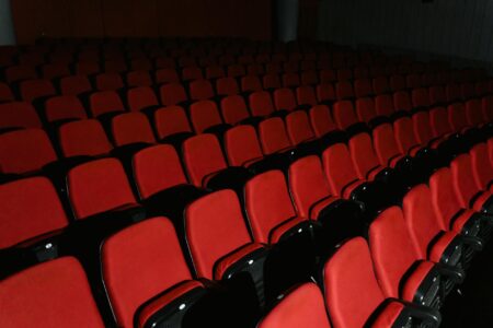 Empty red theater seats in a Broadway-style auditorium