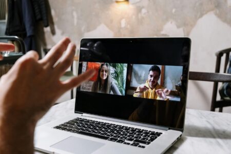 Person participating in video conference call from home office setup