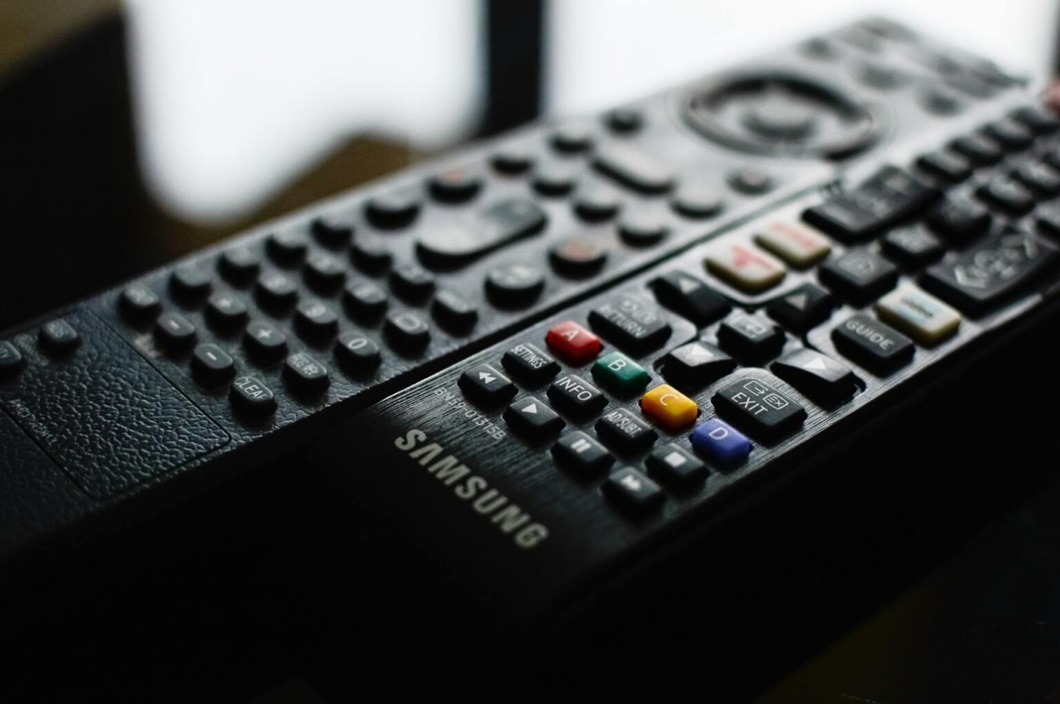 Television remote control on couch representing viewer interaction with streaming content