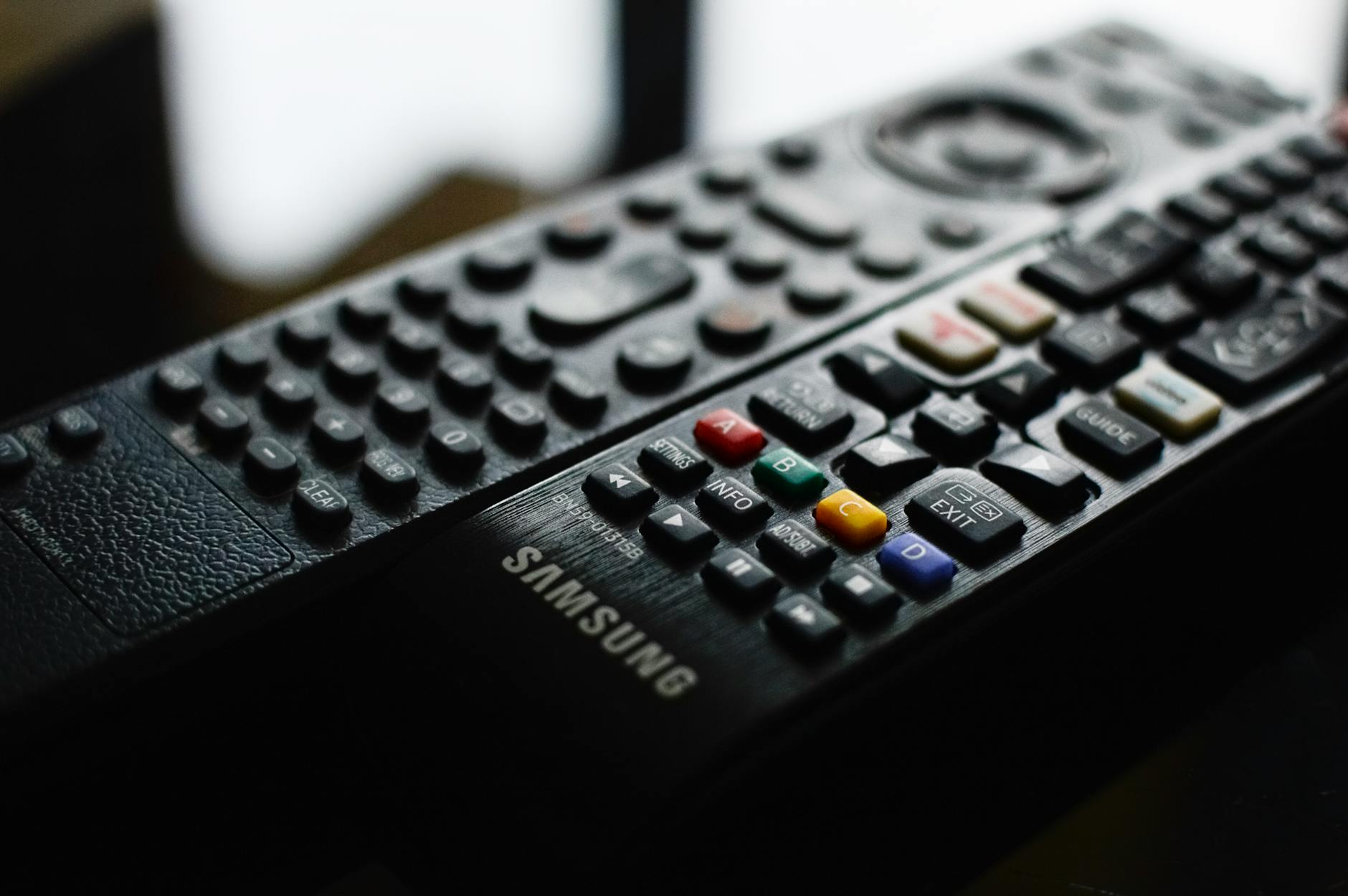 Television remote control on couch representing viewer interaction with streaming content