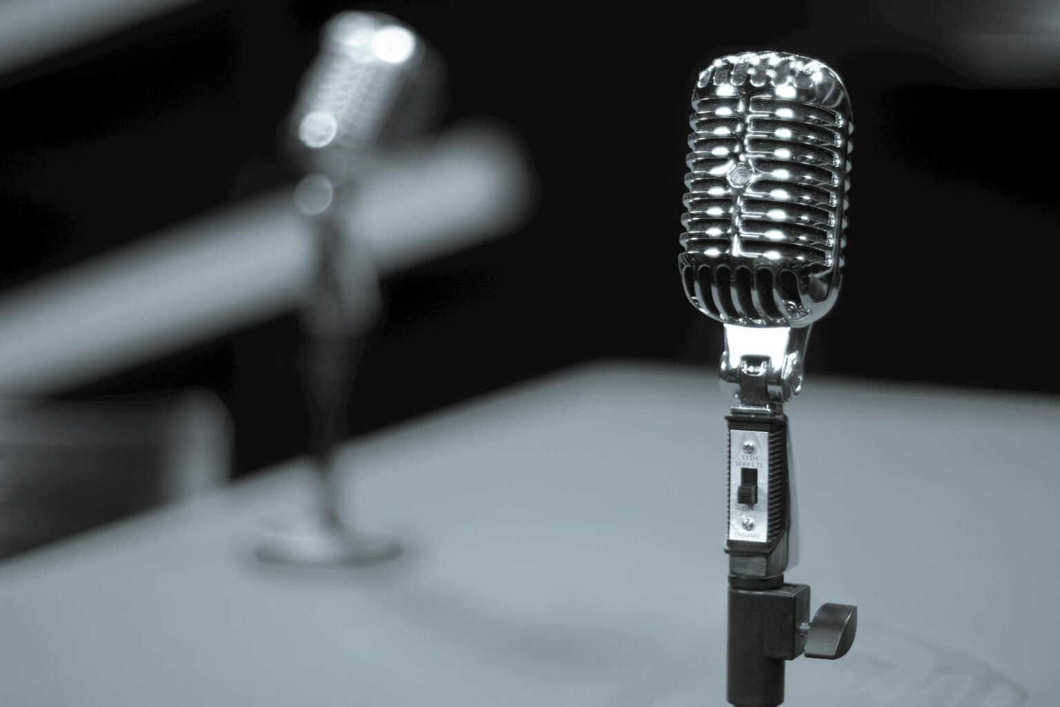 Professional radio microphone in broadcasting studio with equipment in background