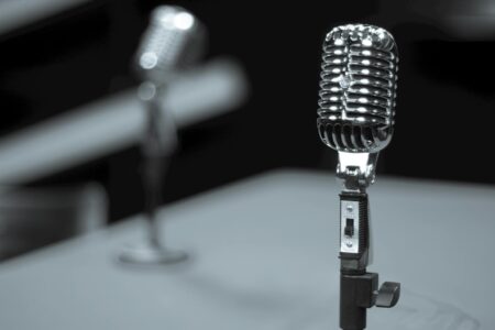 Professional radio microphone in broadcasting studio with equipment in background