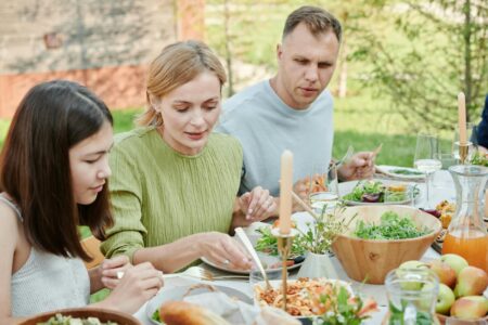 Large family gathering with multiple generations sitting together outdoors