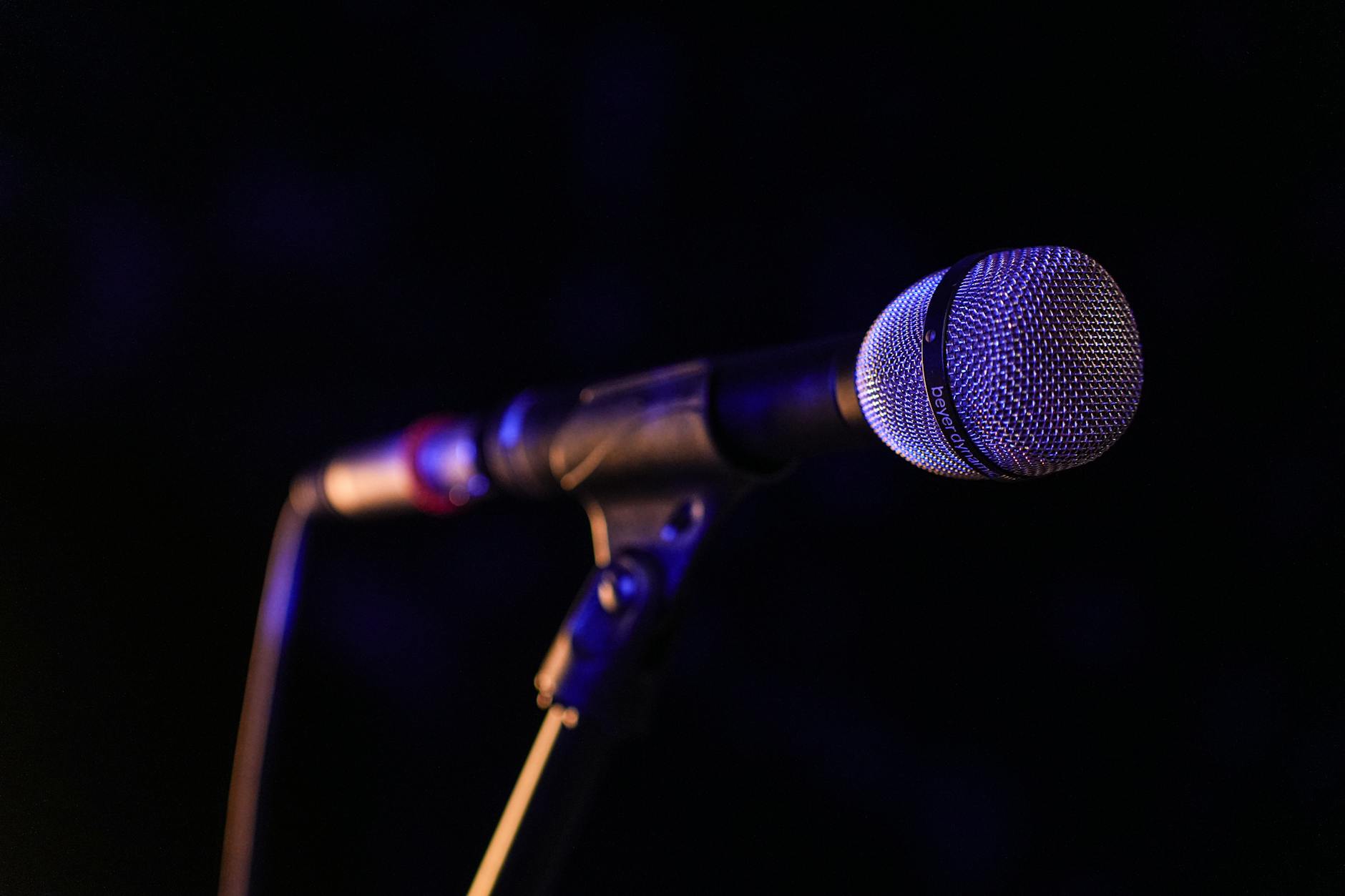 Vintage microphone on dimly lit stage with warm lighting