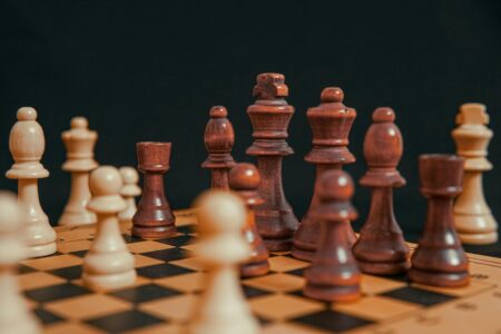 Chess pieces arranged on wooden board showing strategic gameplay