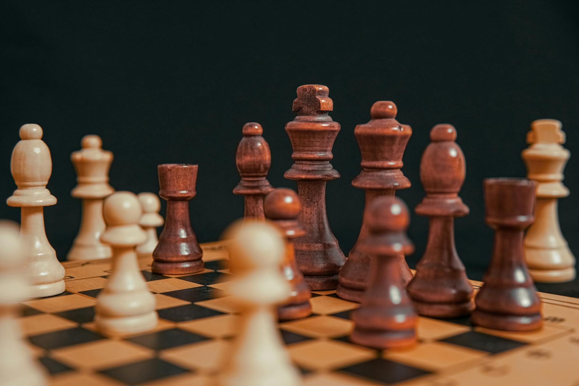 Chess pieces arranged on wooden board showing strategic gameplay