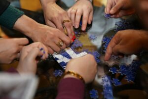 How Escape Rooms Evolved Into Team Therapy for Modern Relationships Group of people working together to solve puzzles in an escape room setting