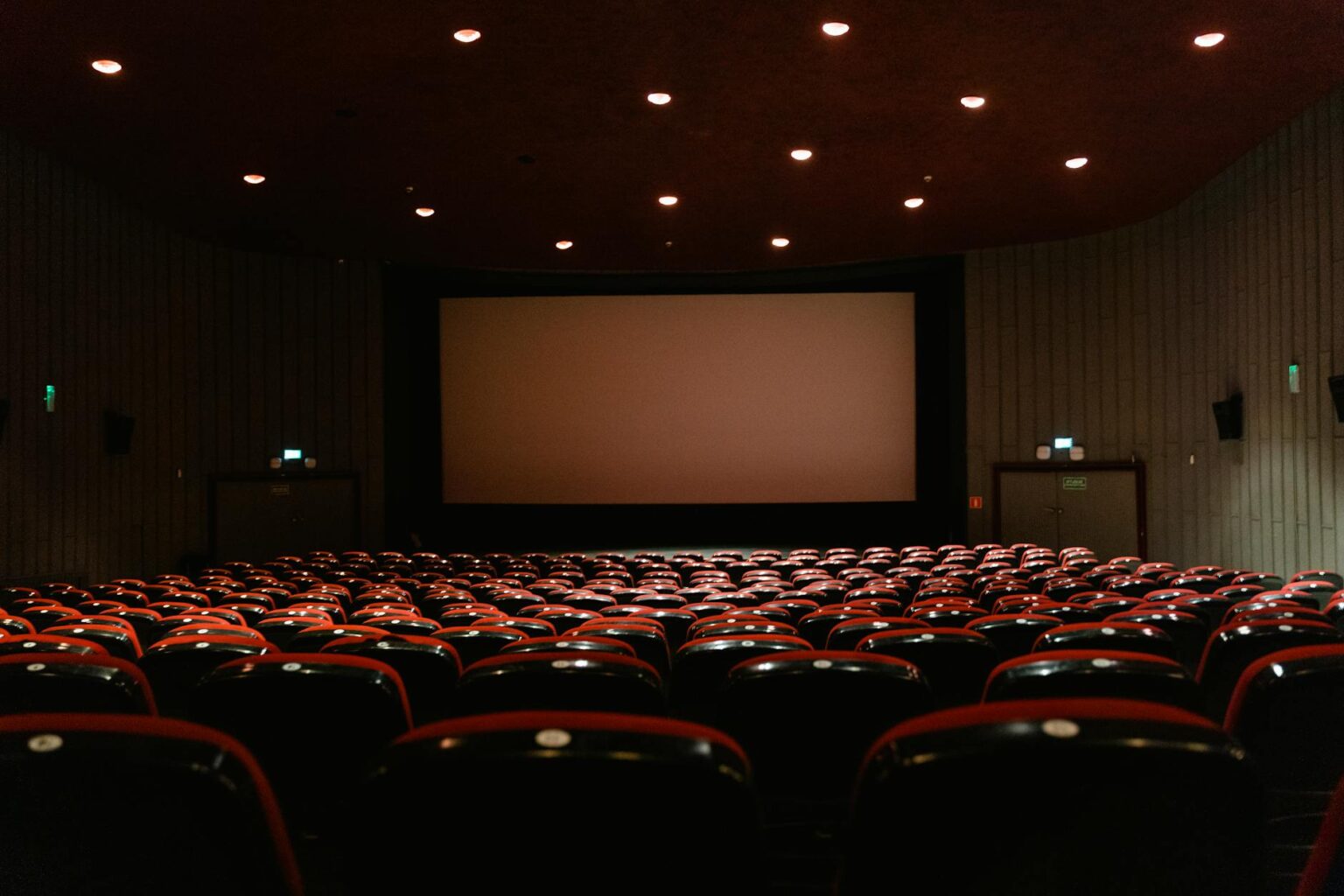 Modern movie theater with rows of reclining seats and large screen