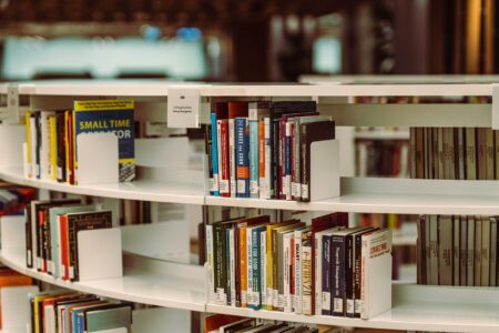 Close-up view of books on library shelves with warm lighting