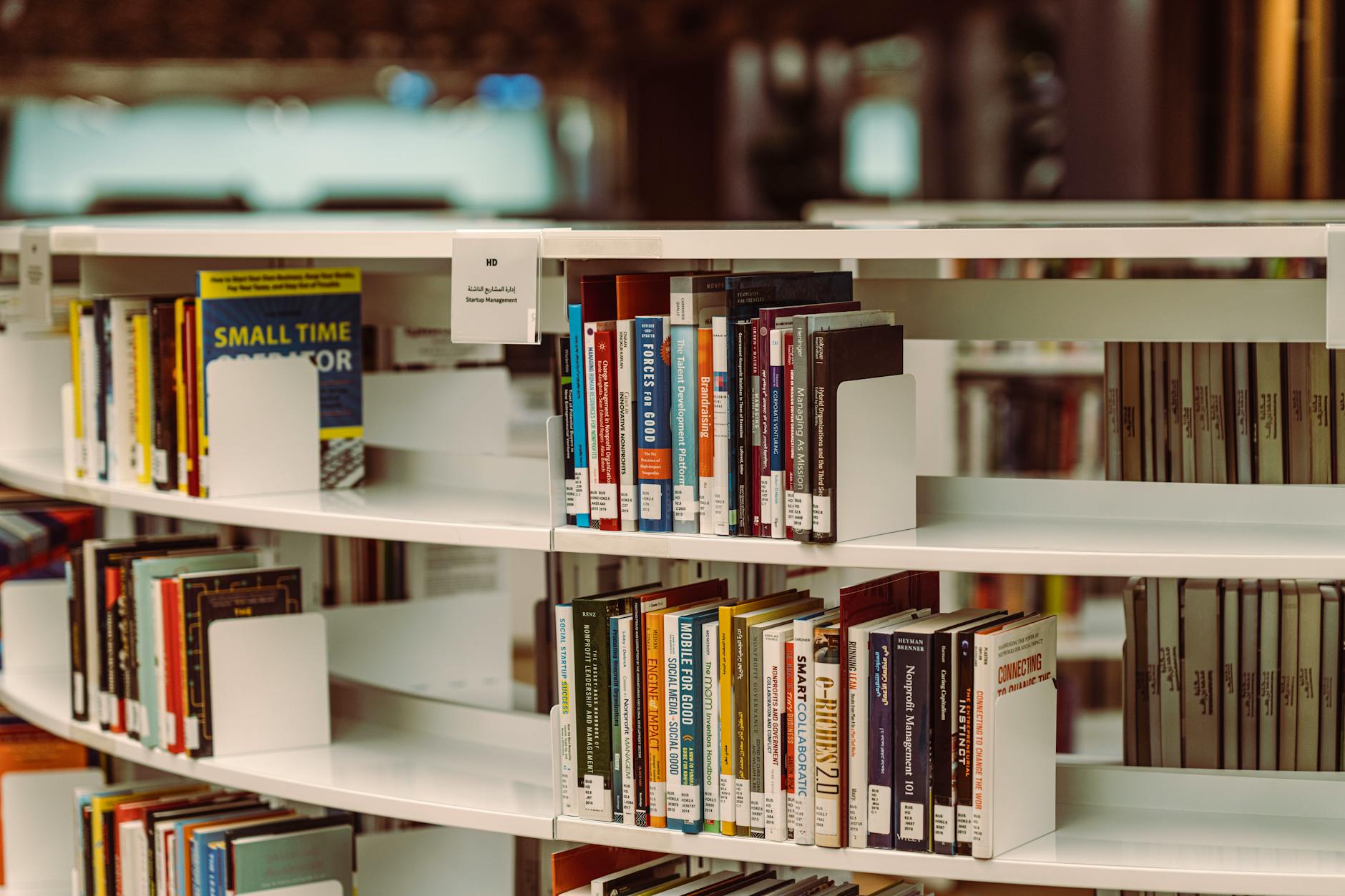 Close-up view of books on library shelves with warm lighting