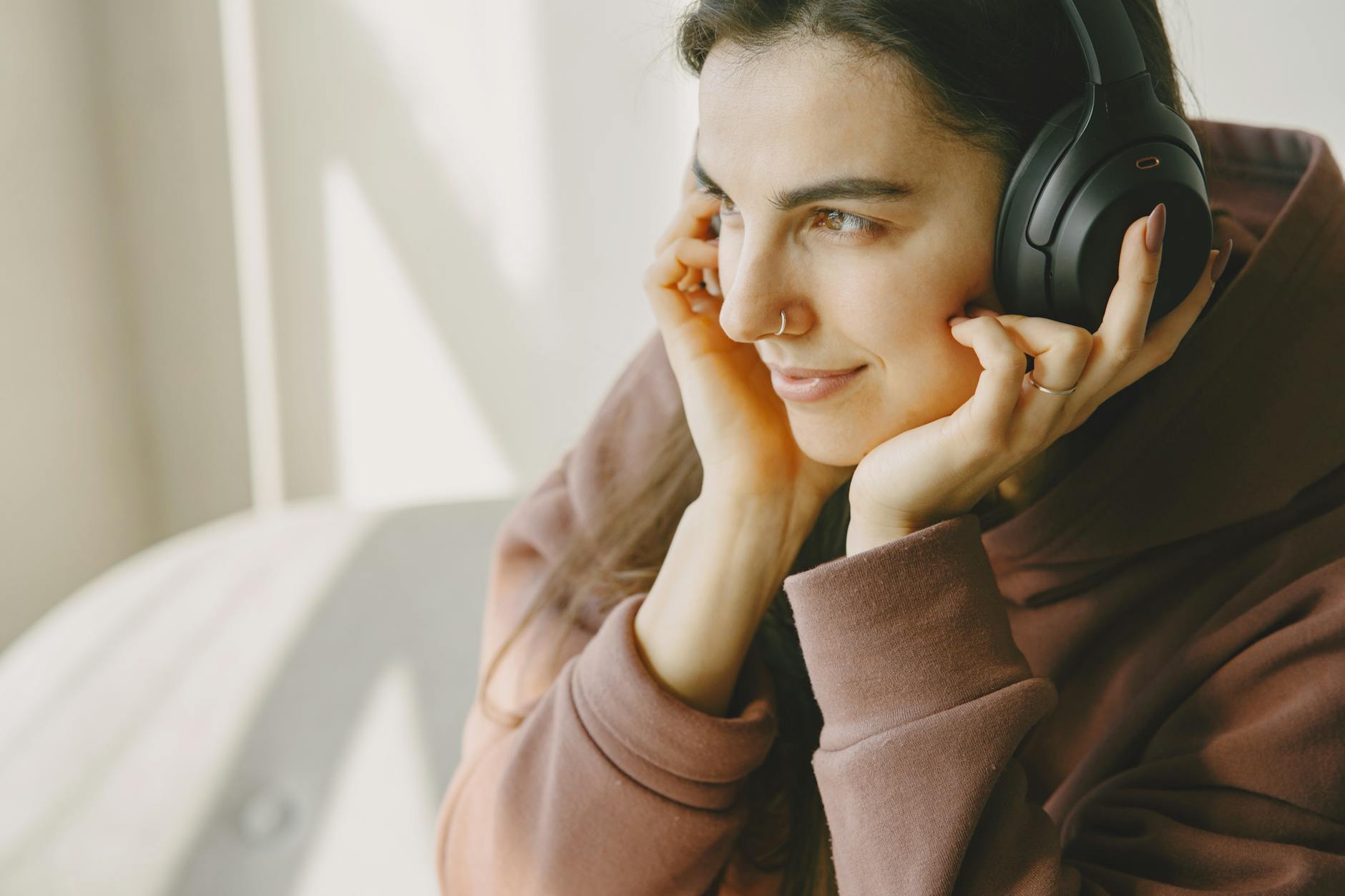 Woman wearing headphones and listening intently, representing podcast audiences consuming true crime content