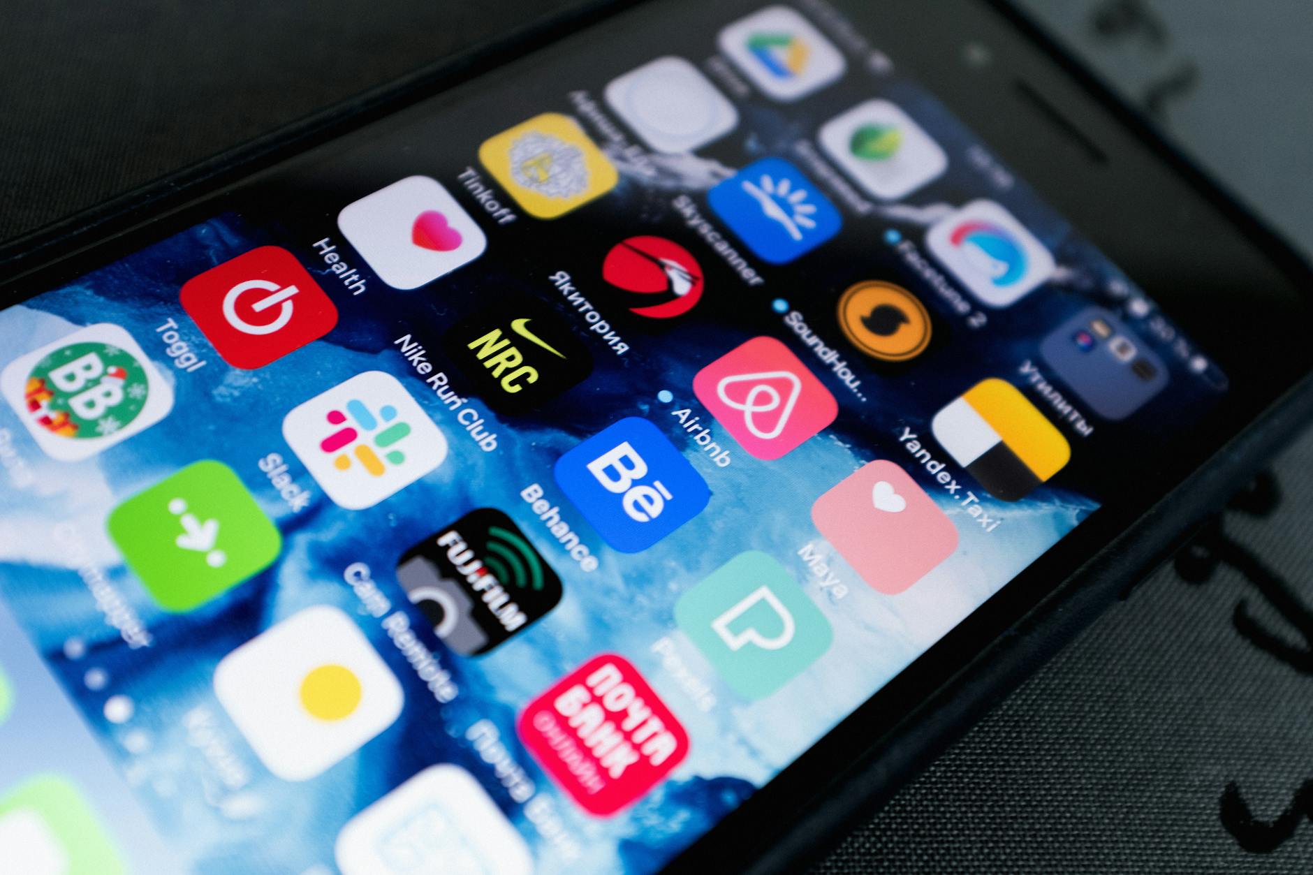 Hand holding smartphone showing multiple subscription app icons
