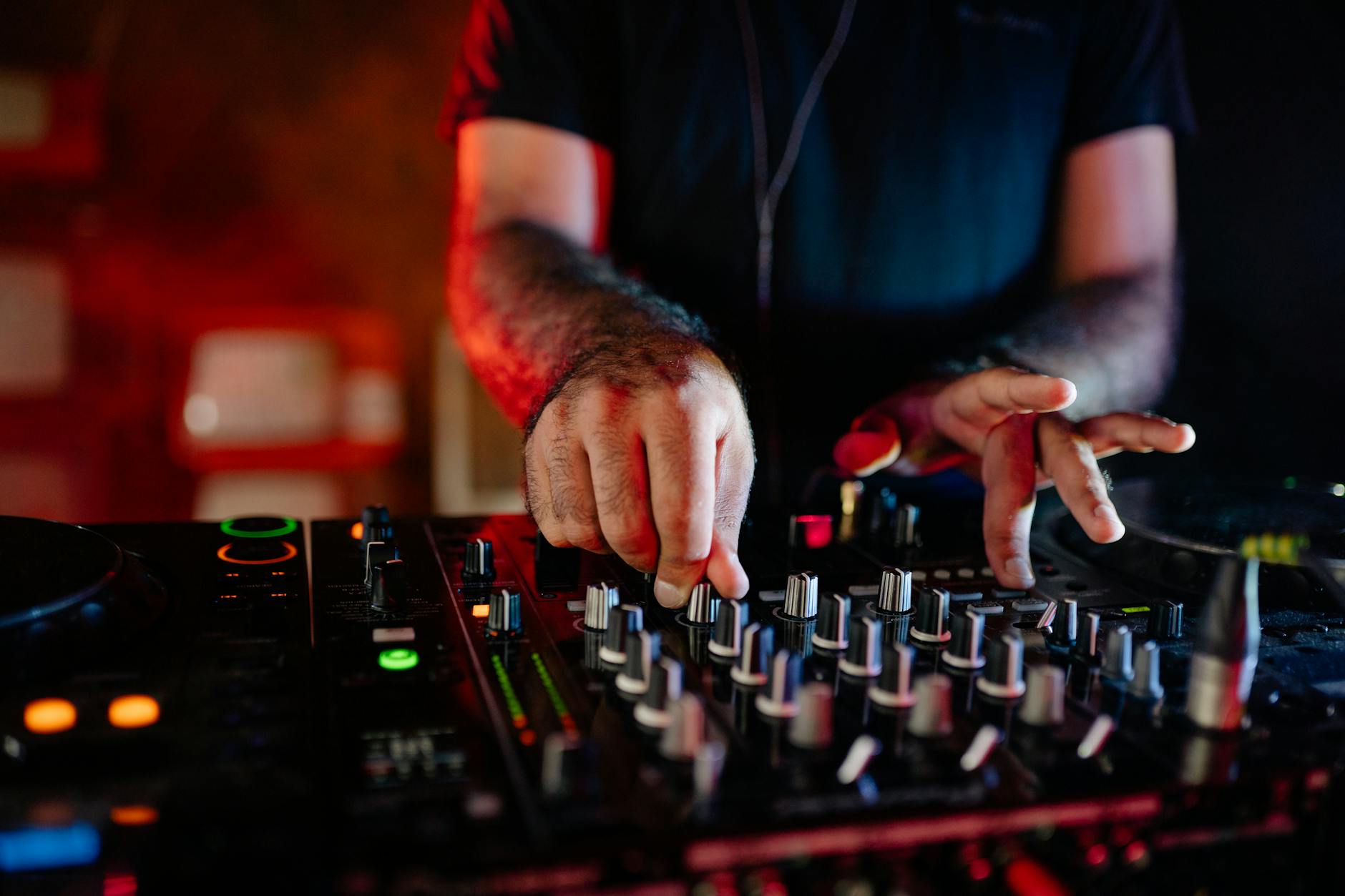Professional DJ working at mixing console with headphones