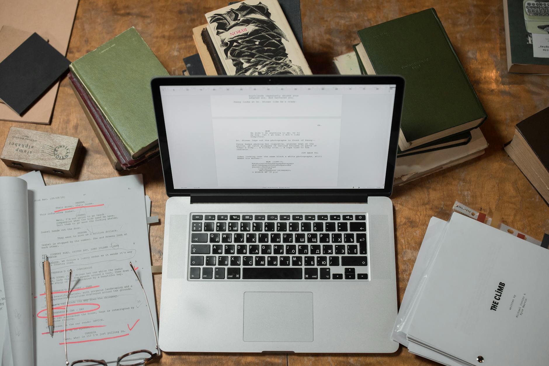 Stack of business books on a wooden desk in an office environment