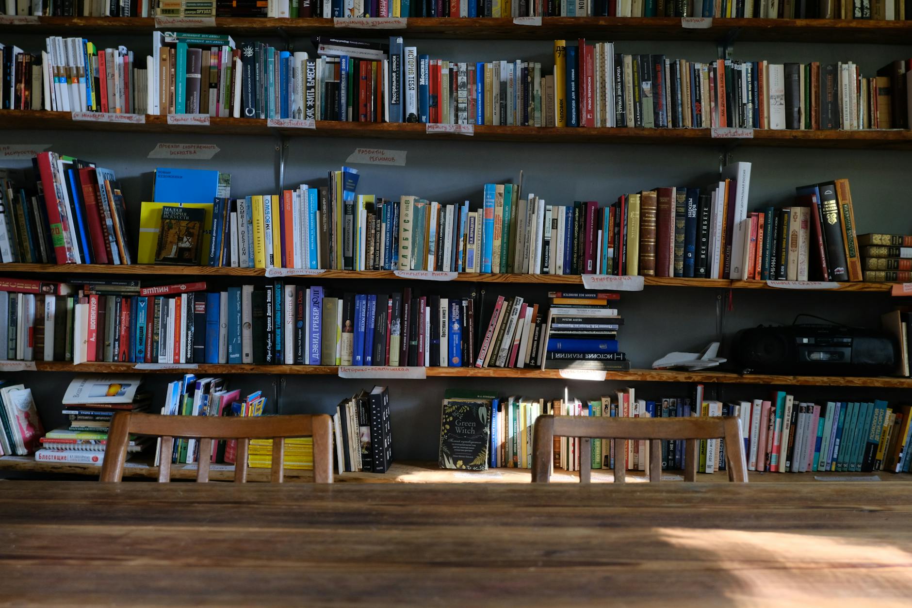 Stack of business books on wooden table with notebooks and pens