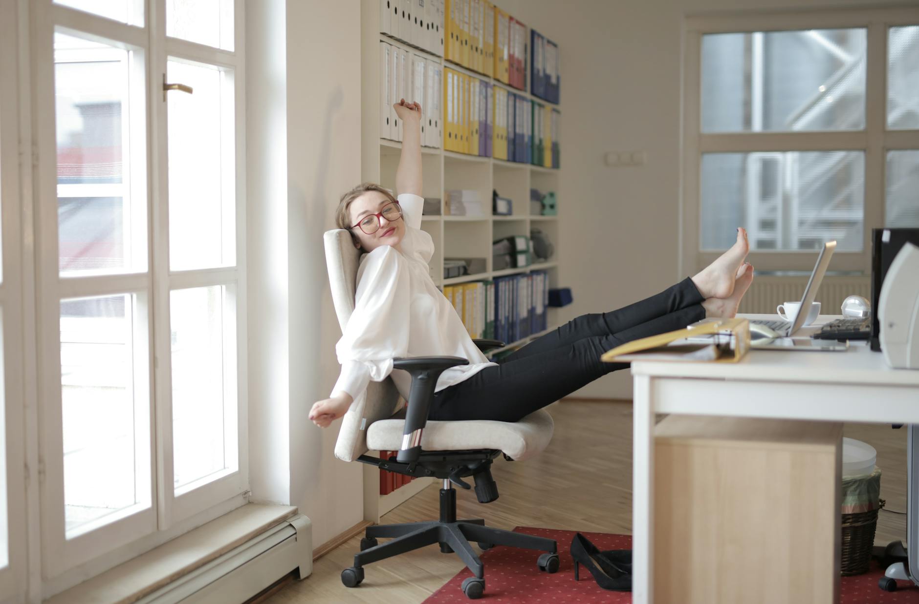 Professional standing at adjustable desk in bright office environment