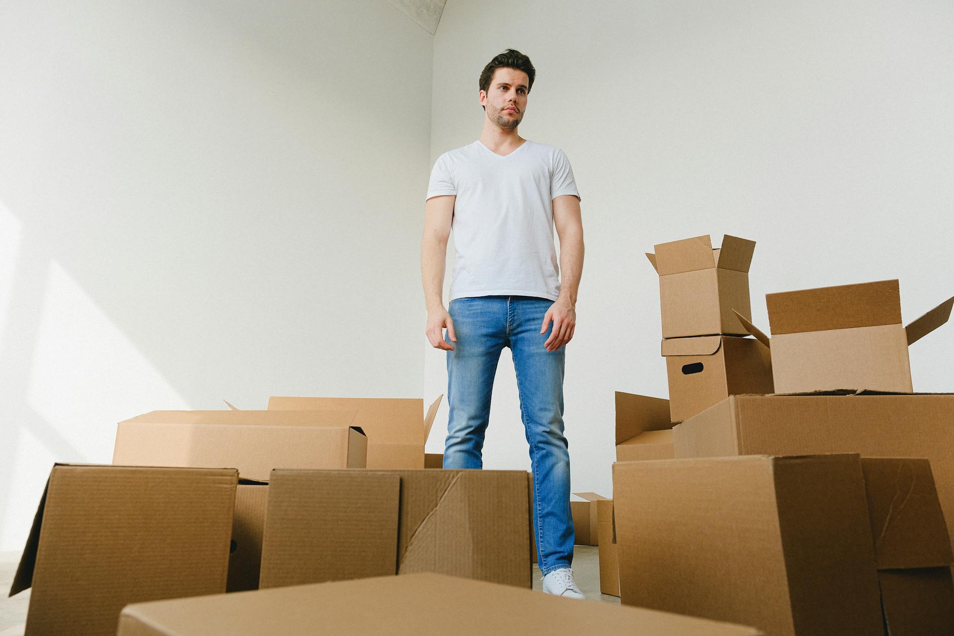Person packing moving boxes in apartment, illustrating frequent millennial relocations