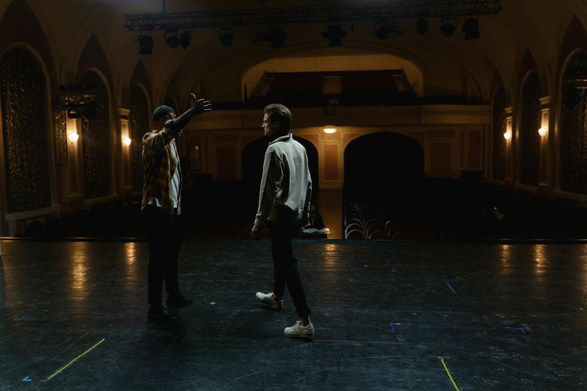 Performers on stage in close proximity to audience members in small theater setting