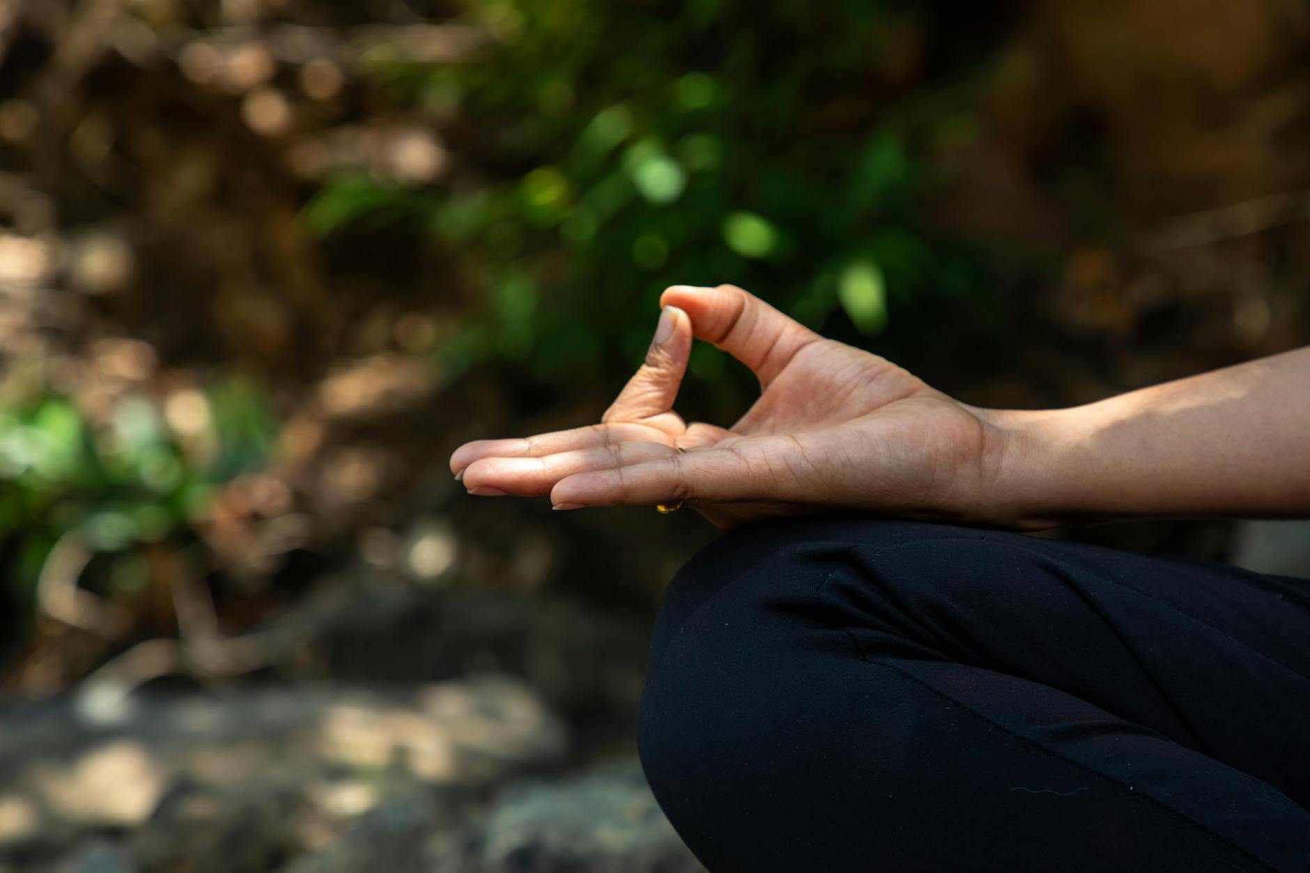 Person sitting peacefully in meditation posture in natural setting