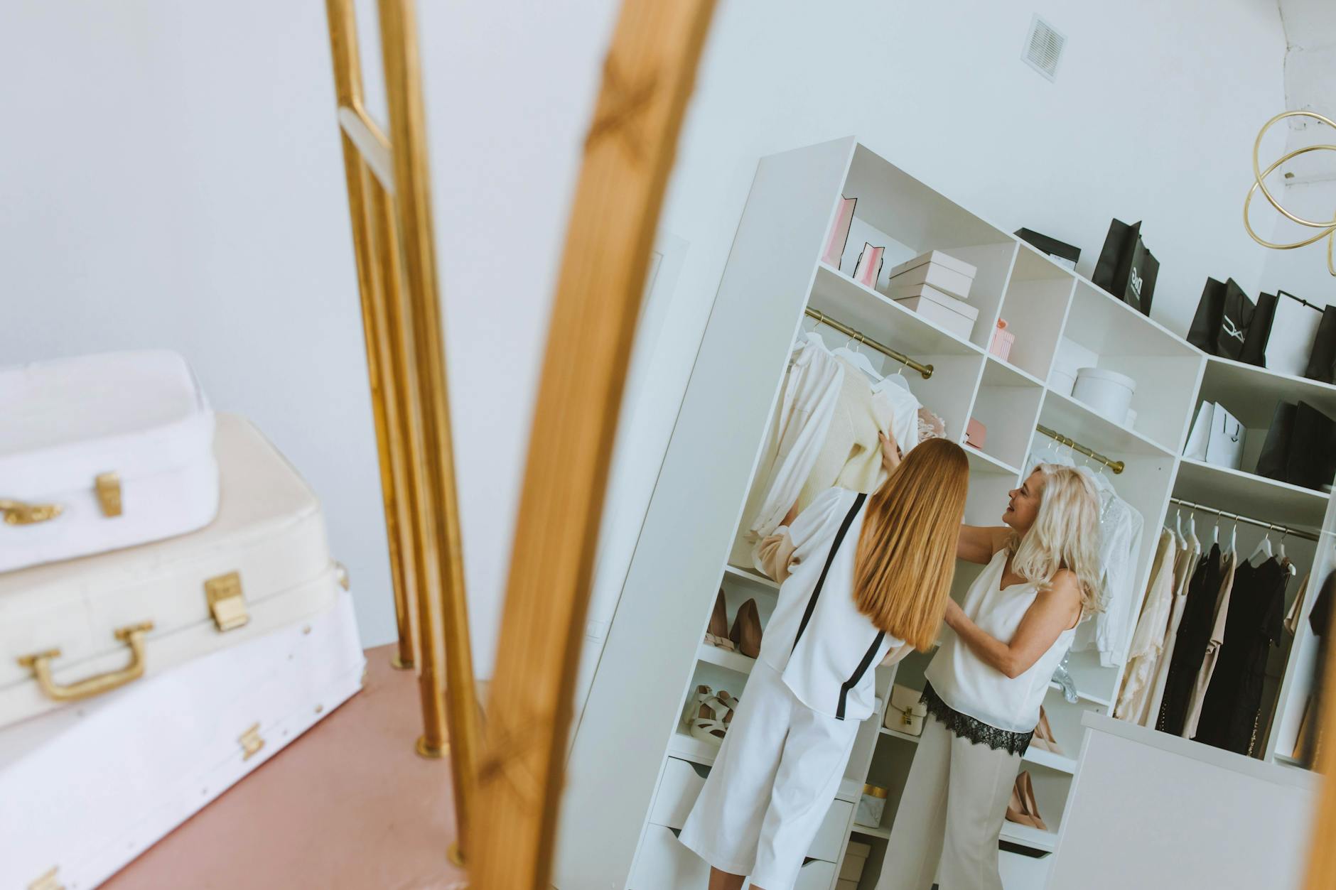 Person organizing clothes and planning outfits in modern closet space