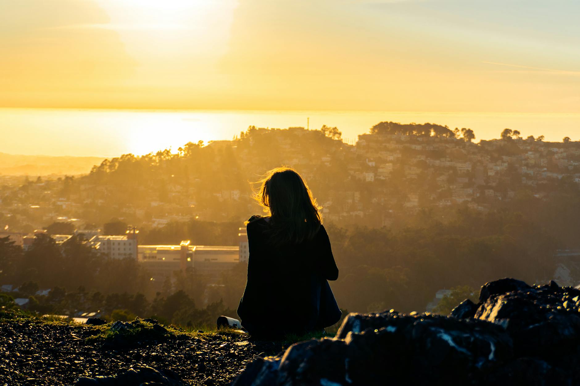 Silhouette of person sitting quietly watching sunset