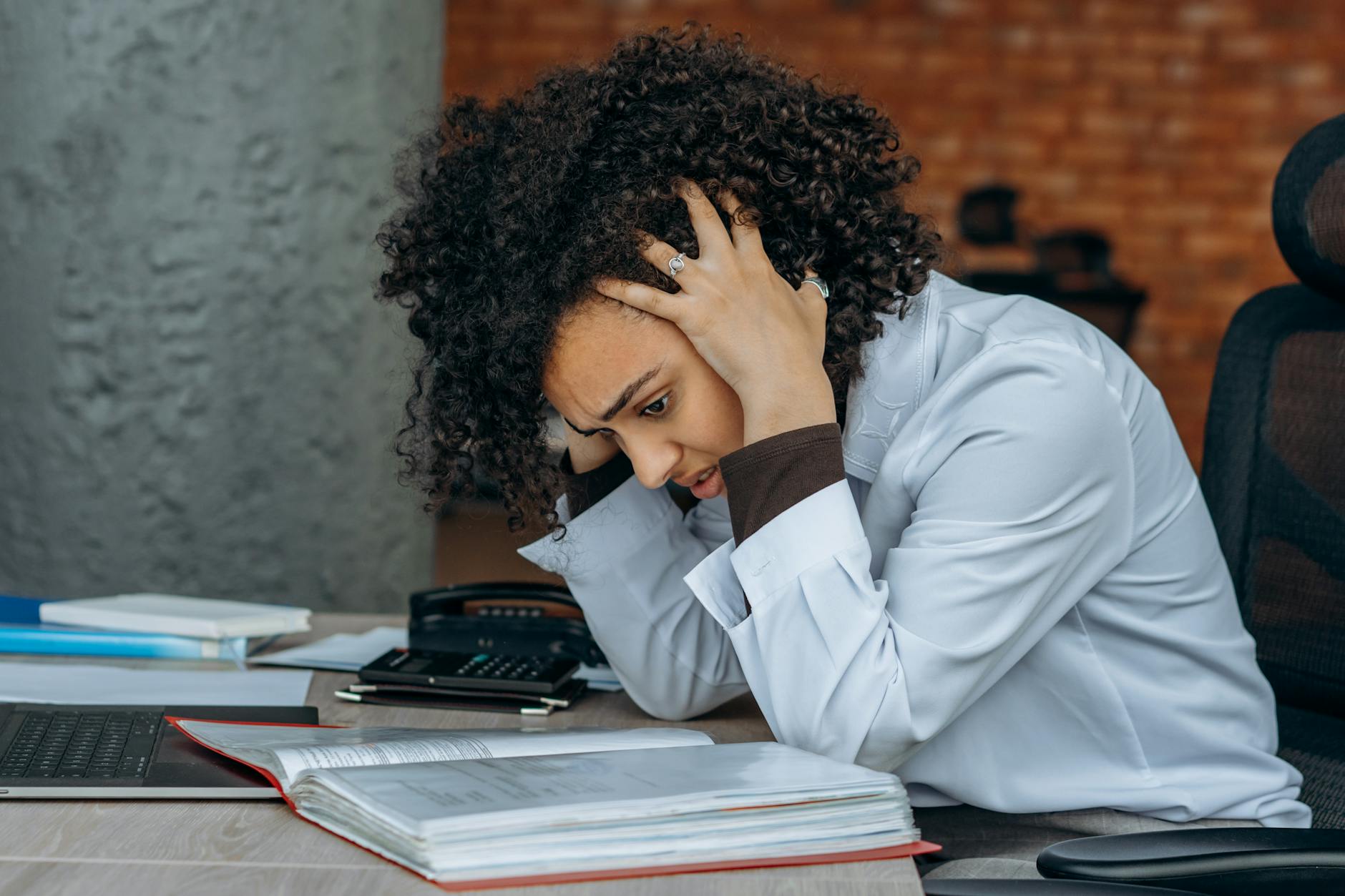Young woman looking contemplative and slightly stressed while sitting indoors