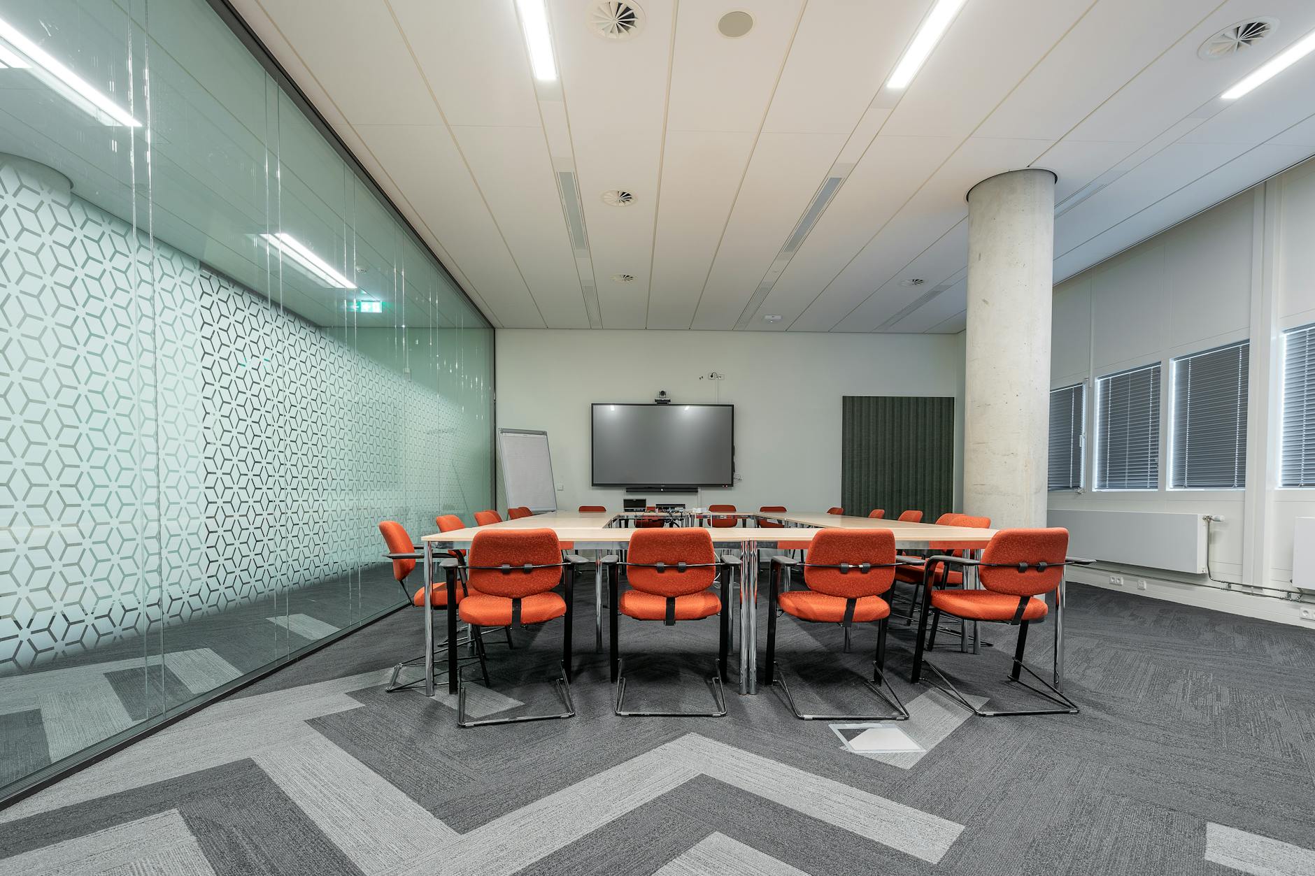 Empty corporate boardroom with long table and executive chairs in modern office building