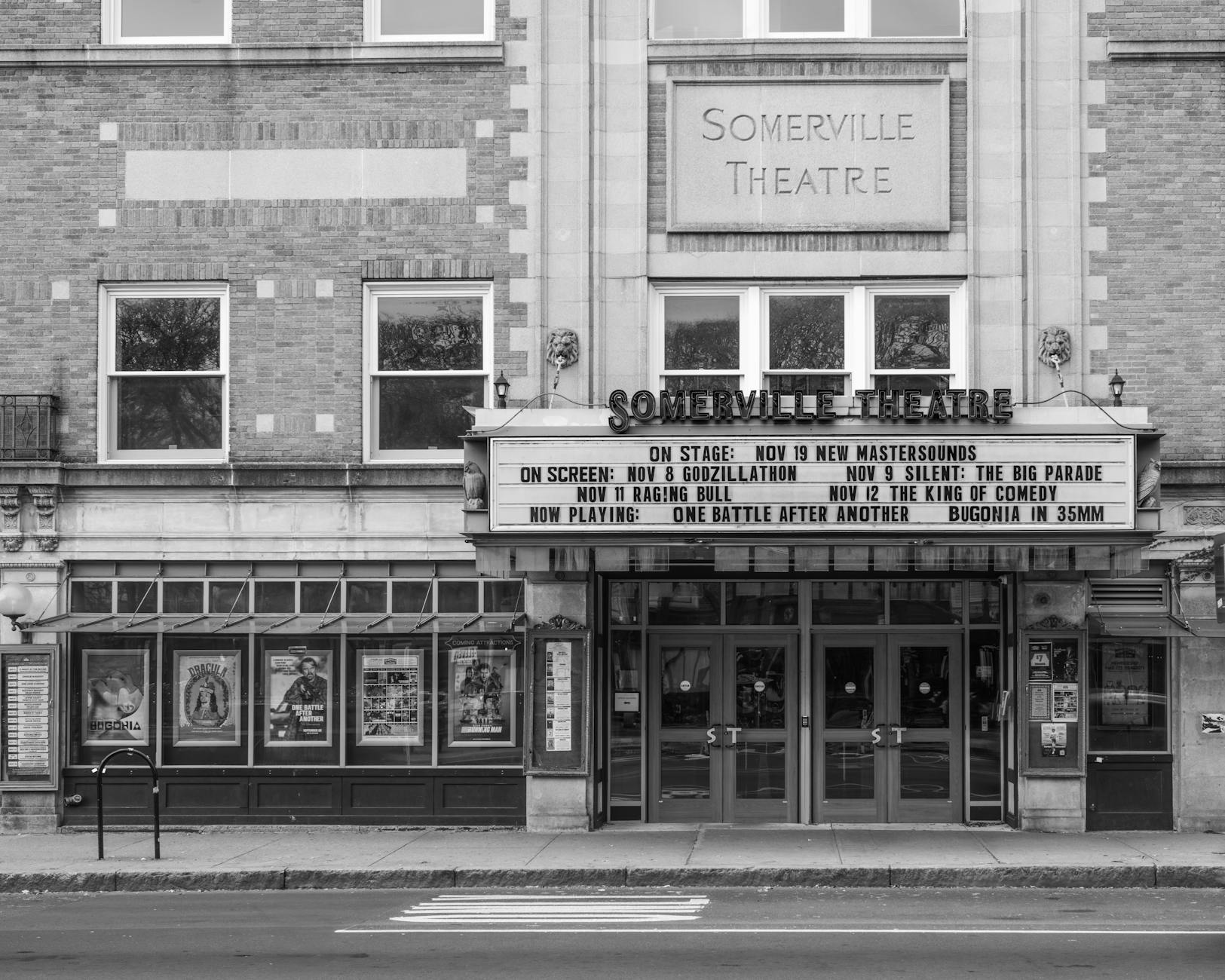 Illuminated movie theater marquee and entrance at night