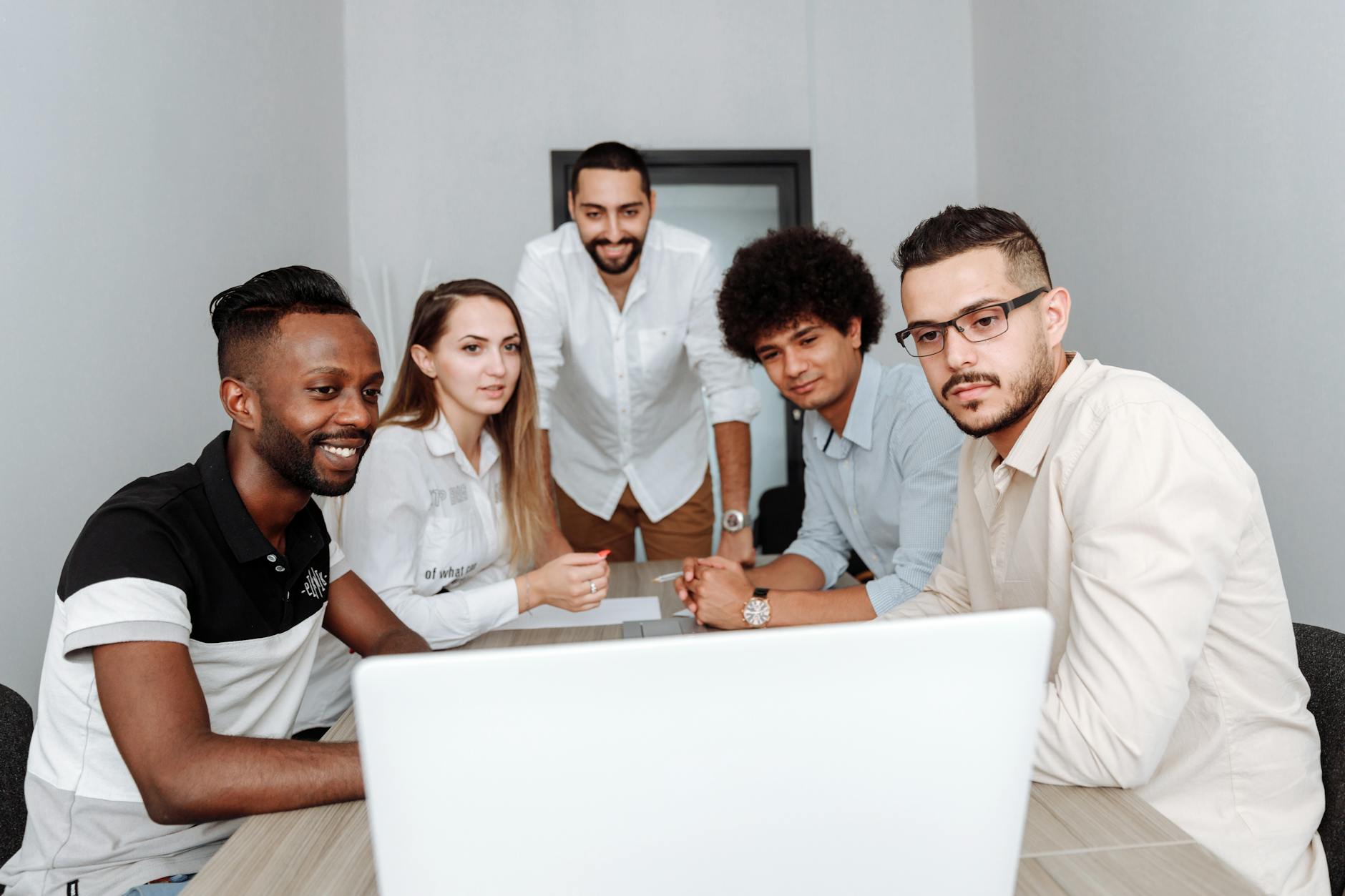 Diverse group of professionals in a bright modern office meeting room discussing workplace wellness initiatives