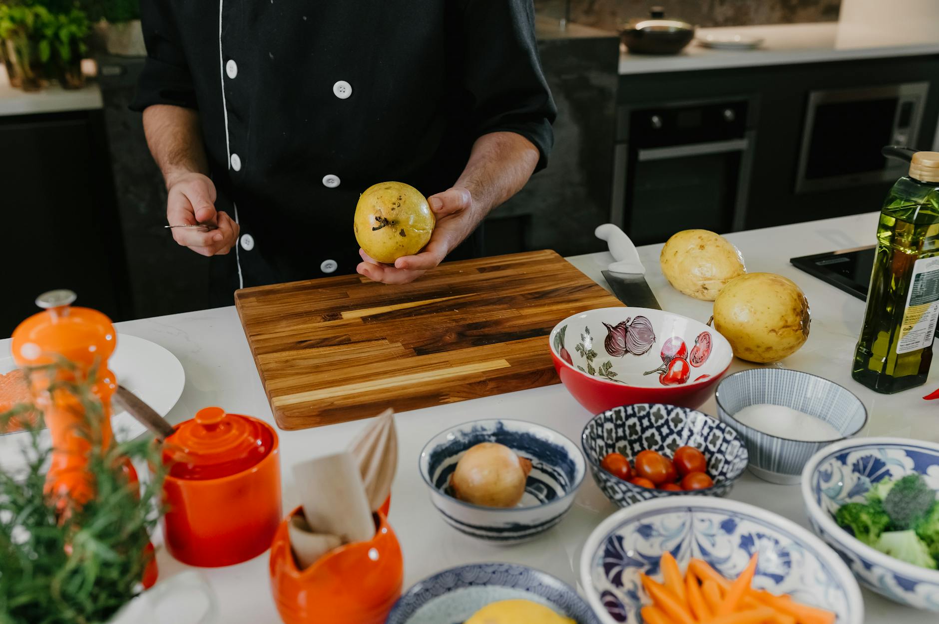 Person preparing a meal in a modern kitchen with fresh ingredients and cooking utensils