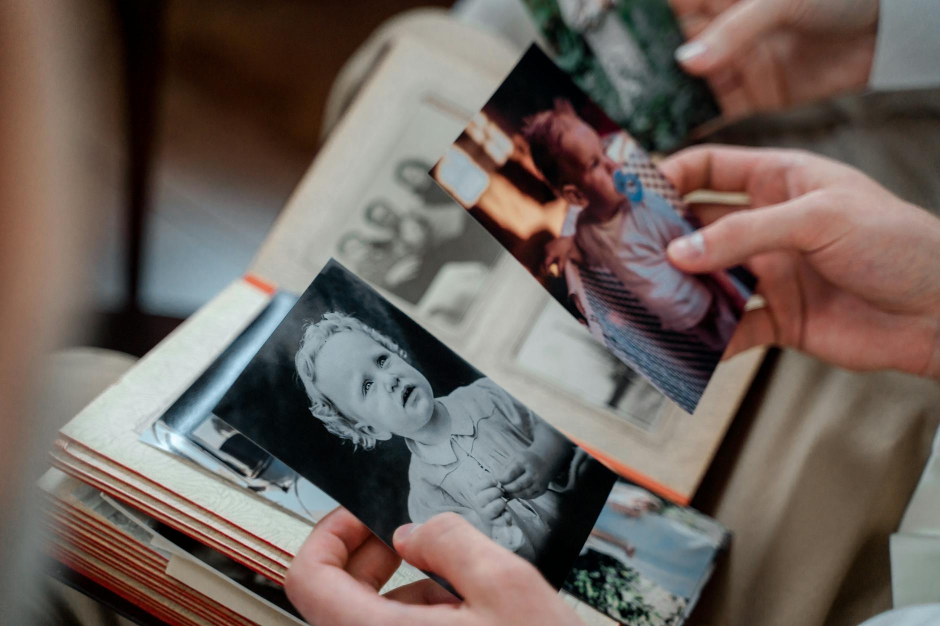 Organized photo albums and printed pictures arranged neatly on wooden table