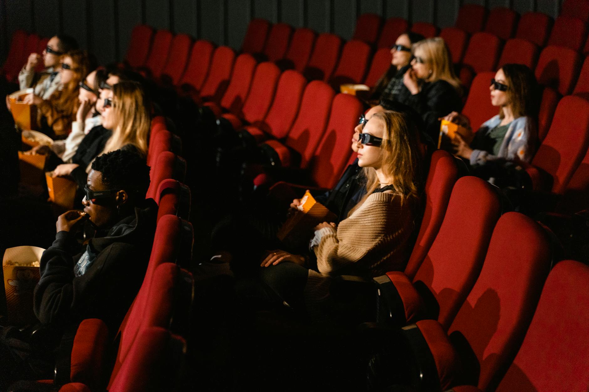 Empty movie theater seats facing a blank screen
