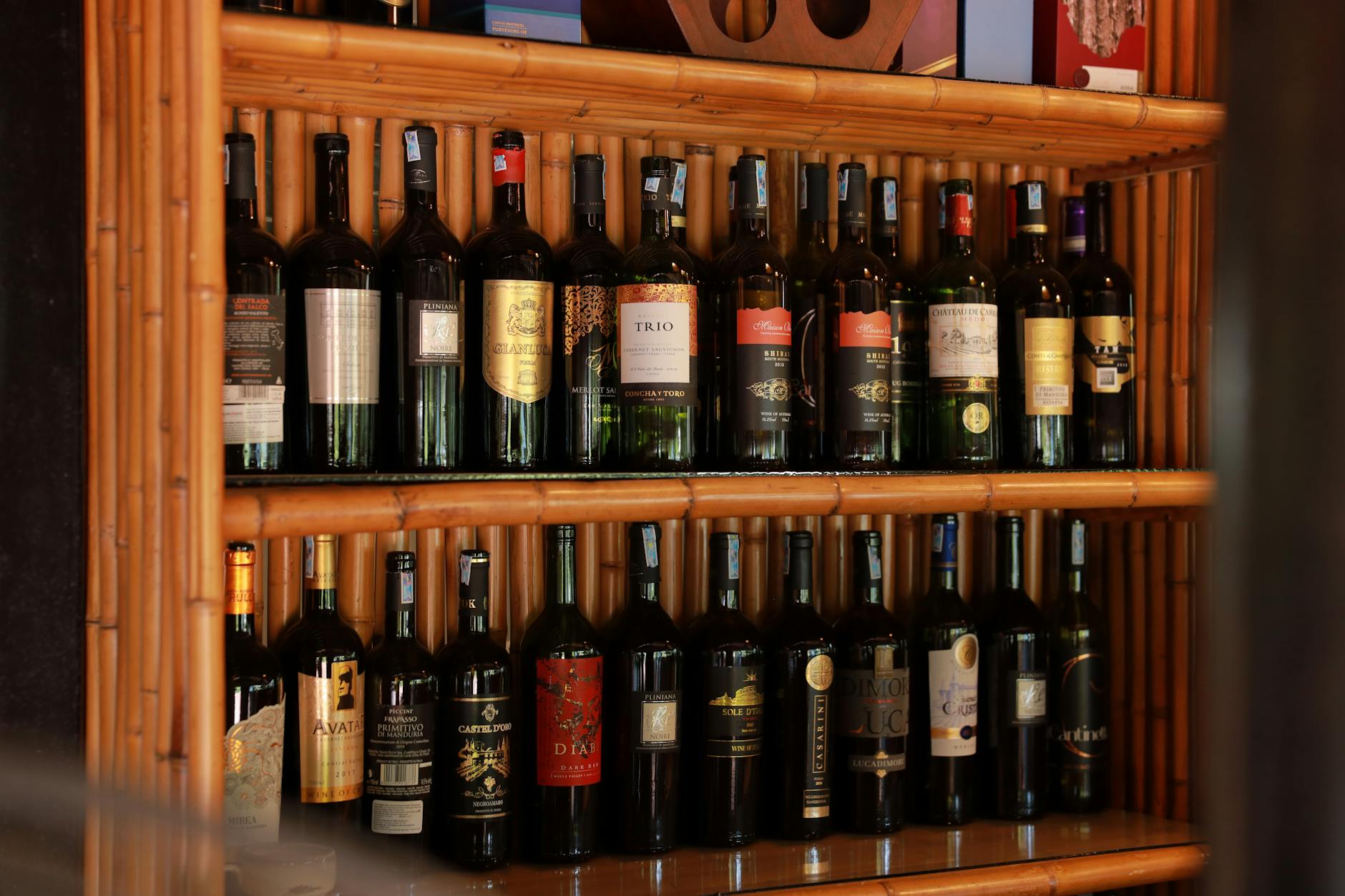 Collection of wine bottles with various natural wine labels displayed on shelf