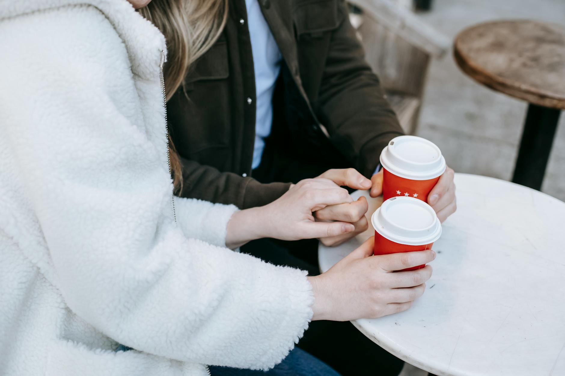 Happy couple having coffee together at a cafe table, representing successful real-world connection