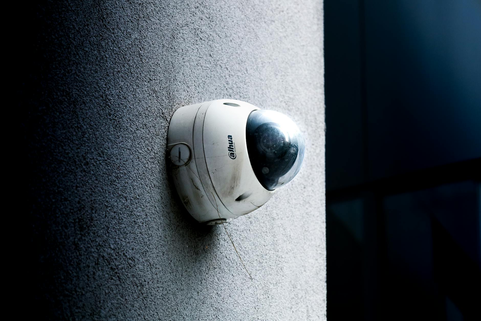 Security surveillance camera mounted on wall, symbolizing corporate monitoring and data collection