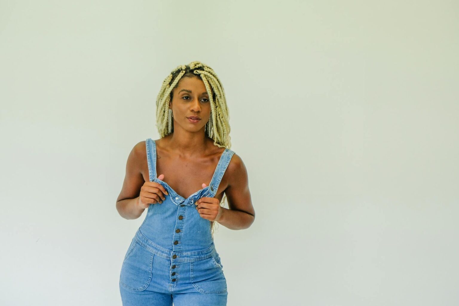 Person wearing styled denim overalls with fashionable accessories