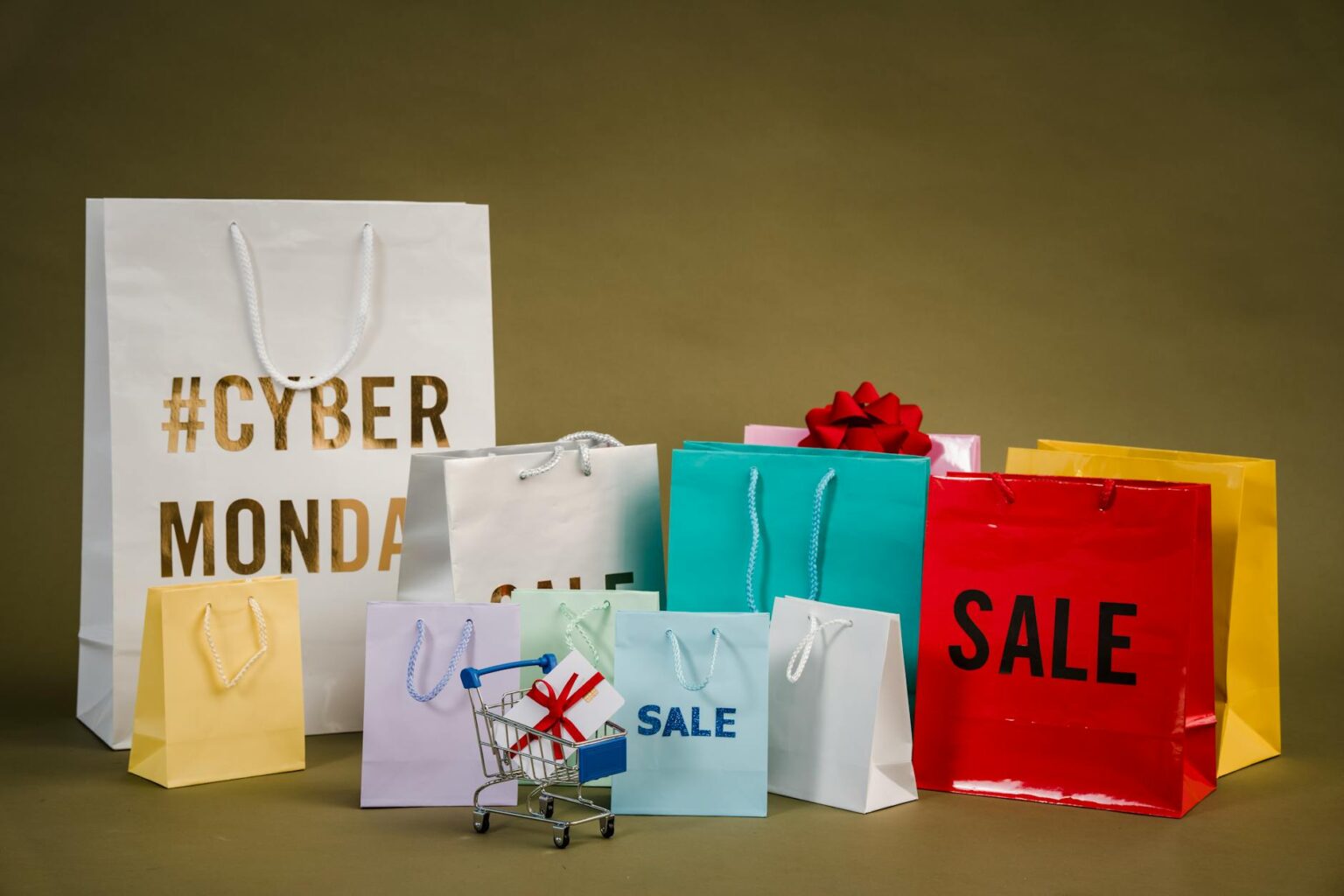 Multiple colorful shopping bags arranged on white surface representing retail sales