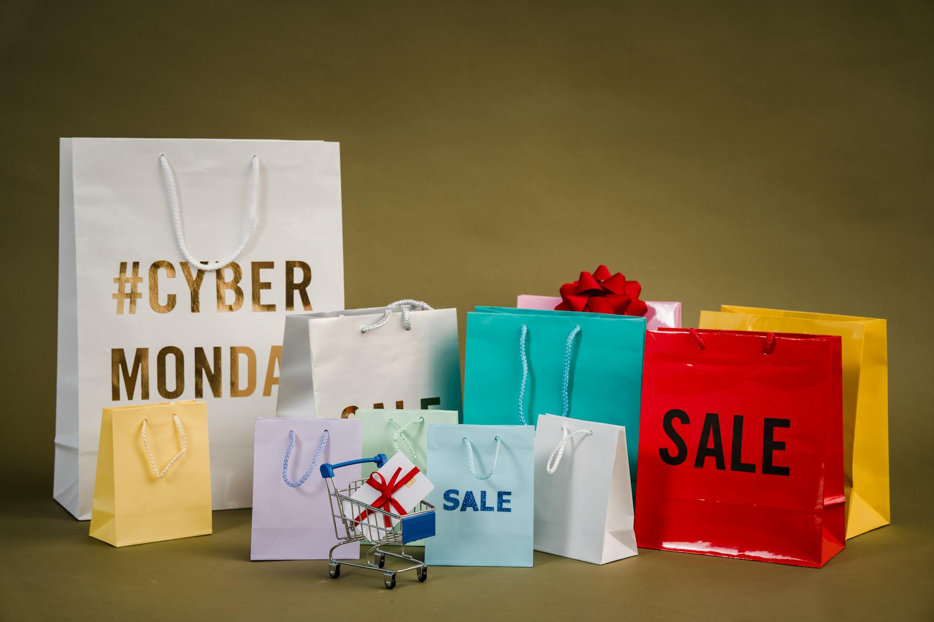 Multiple colorful shopping bags arranged on white surface representing retail sales