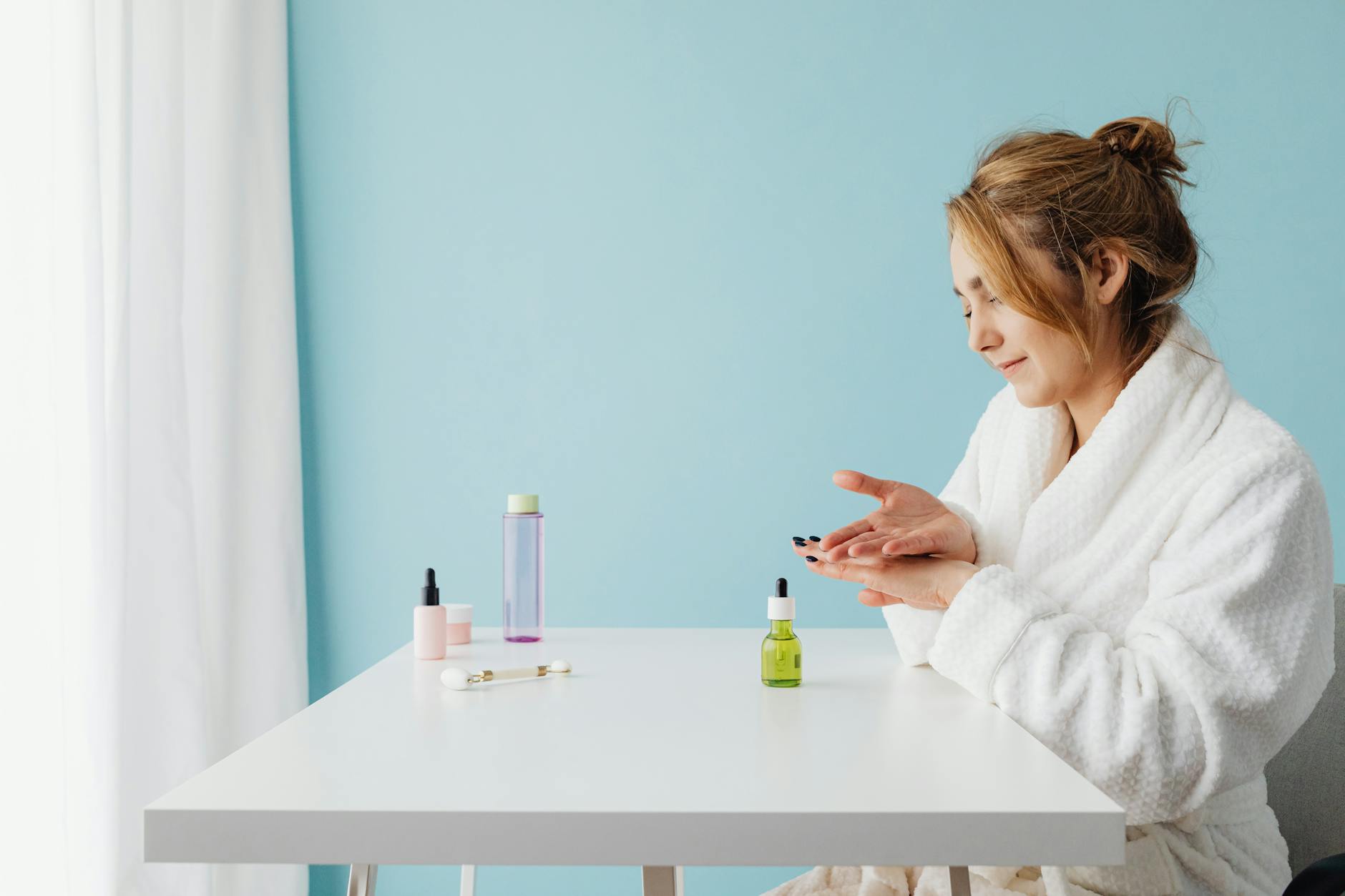 Woman applying skincare products in modern bathroom