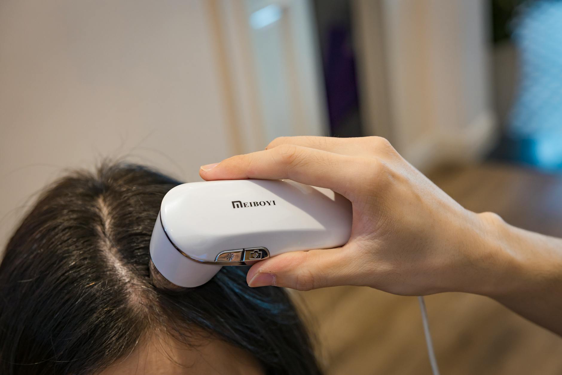 Person applying rollerball serum treatment to scalp and hair roots