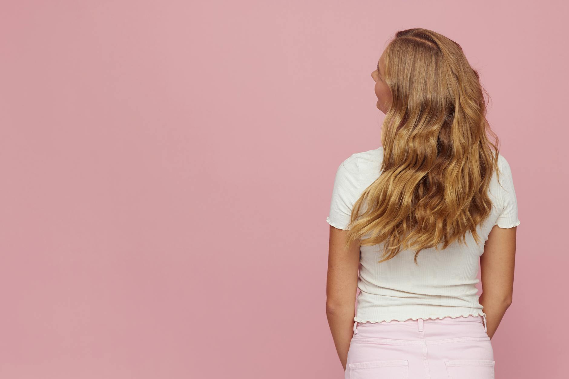 Woman with layered hair and subtle highlights styled in natural waves